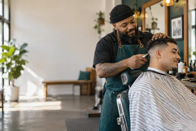 Barber trimming a client's fade in a classic barbershop chair